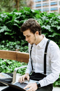 Man looking at camera while sitting on mobile phone