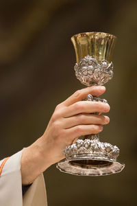 Cropped hand of priest holding chalice in church