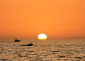 Scenic view of sea against orange sky