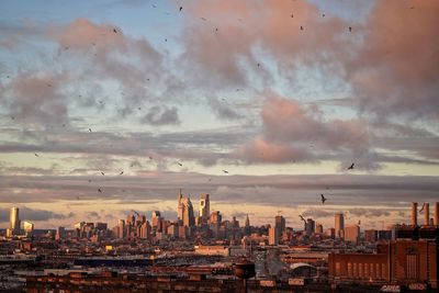 Panoramic view of buildings against cloudy sky