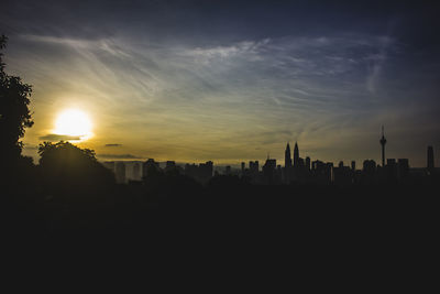 Silhouette buildings against sky during sunset