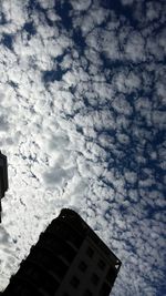 Low angle view of building against cloudy sky