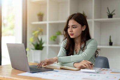 Young woman using laptop at office