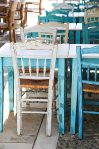 Empty chairs and tables in turquoise white brown and blue in row outdoors 