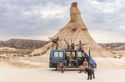 Carefree friends with dog and van at bardenas reales, navarra, spain