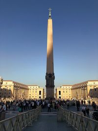 Group of people in town square against clear sky