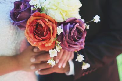 Close-up of hand holding rose bouquet