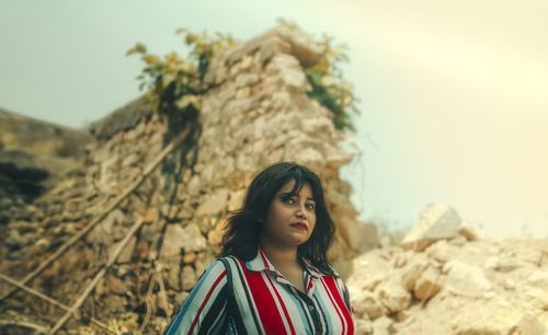 Portrait of beautiful young woman against sky