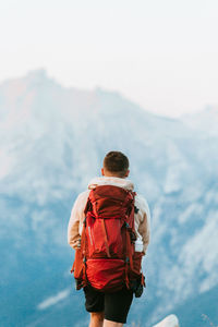 Rear view of man walking against mountain