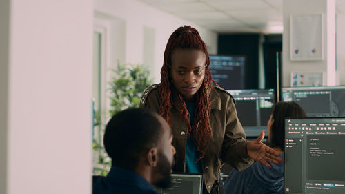 Side view of woman using digital tablet in office