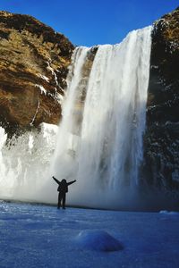 Person standing by waterfall