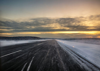 Airport runway in the far north at dawn surrounded by snow