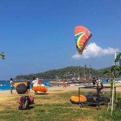 People enjoying at beach against sky