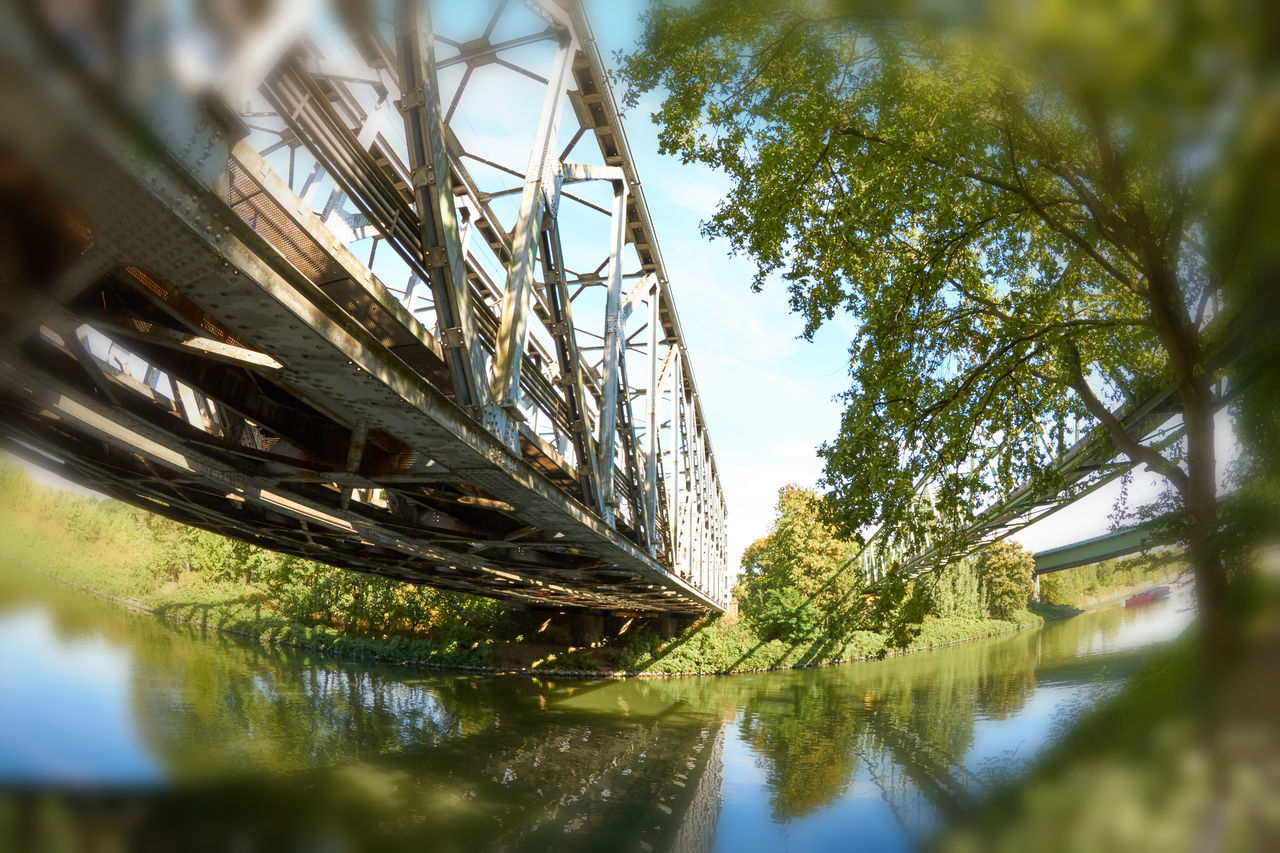 LOW ANGLE VIEW OF BRIDGE BY RIVER AGAINST SKY