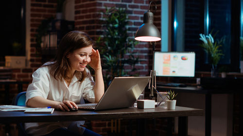 Businesswoman using laptop at table