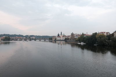 River by buildings against sky in city