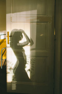 Reflection of woman on door at home