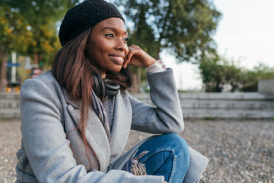 Portrait of smiling young woman sitting outdoors