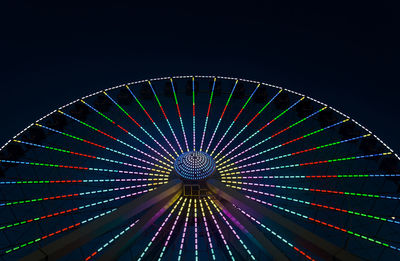 Low angle view of illuminated ferris wheel against sky at night