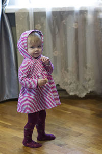 Full length of cute girl standing on wooden floor