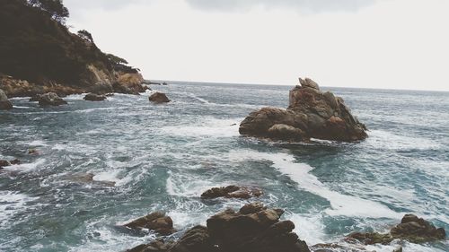Scenic view of rocks in sea against sky