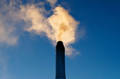 Low angle view of smoke stack against sky