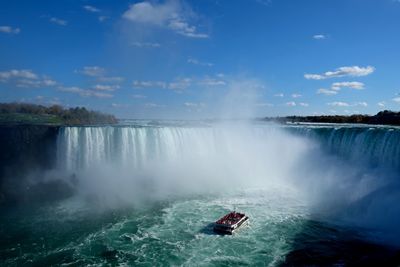 Scenic view of waterfall against sky