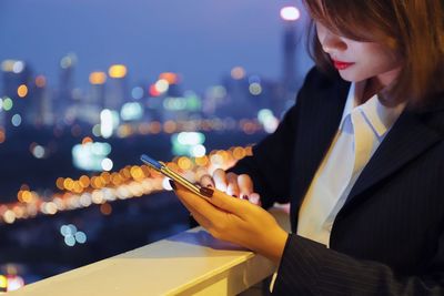 Woman using mobile phone at night