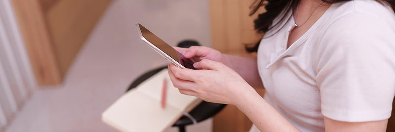 Midsection of woman using mobile phone