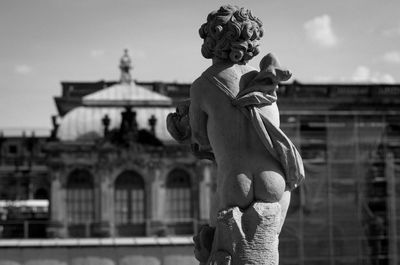 Statue of woman against building