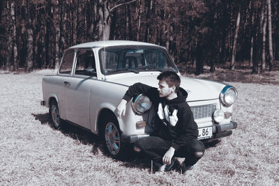 Side view of man driving car on land