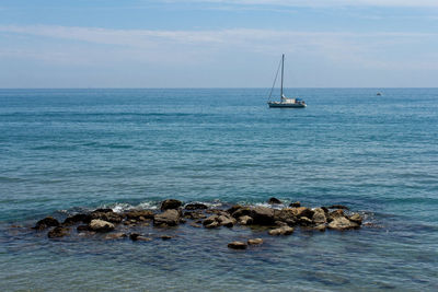 Sailboat sailing on sea against sky