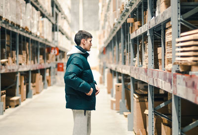 A young guy is looking for goods on the counter in the store.