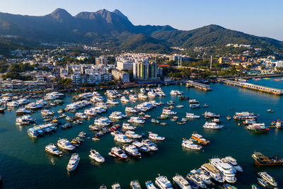 Aerial view of boats moored in sea by townscape