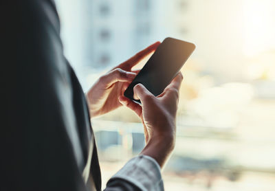 Midsection of man using mobile phone