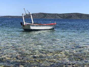 Boat sailing in sea against clear sky