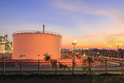 Factory against sky at sunset