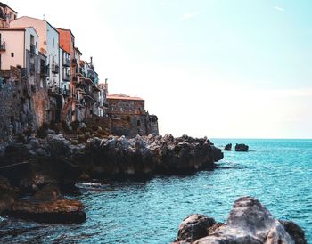 Rock formations by sea against sky in sicilia