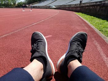 Low section of man relaxing on sports track