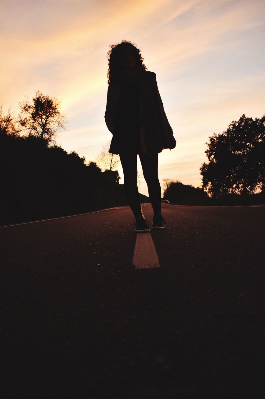 SILHOUETTE WOMAN STANDING ON ROAD AGAINST SKY