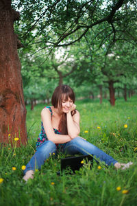 Full length of woman sitting on field