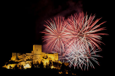 Low angle view of firework display at night