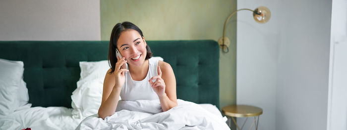 Portrait of young woman sitting at home