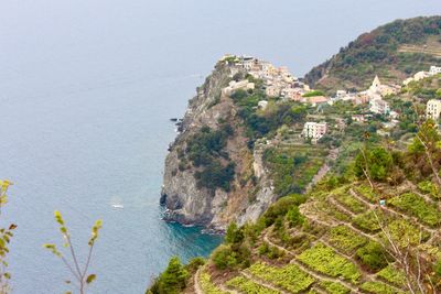 Scenic view of sea by mountains against clear sky