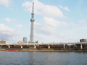 Bridge over river against cloudy sky