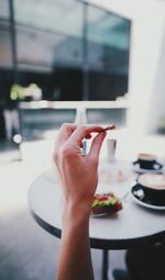 Close-up of hand holding food on table