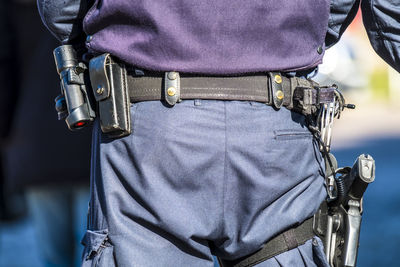 Rear view midsection of police with weapons