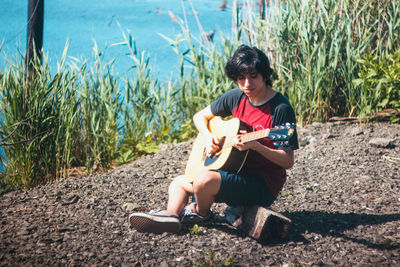 Full length of teenage girl sitting on land