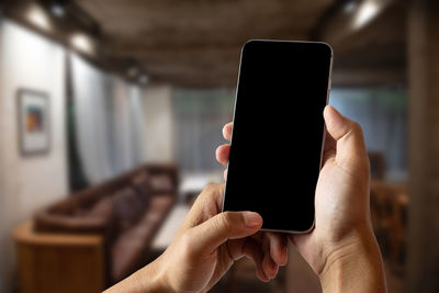 Close-up of hand holding mobile phone