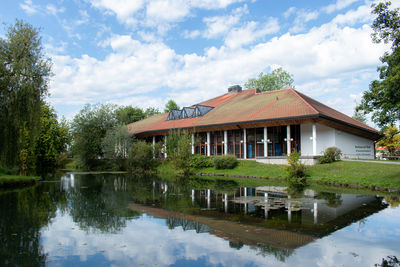 Building by lake against sky